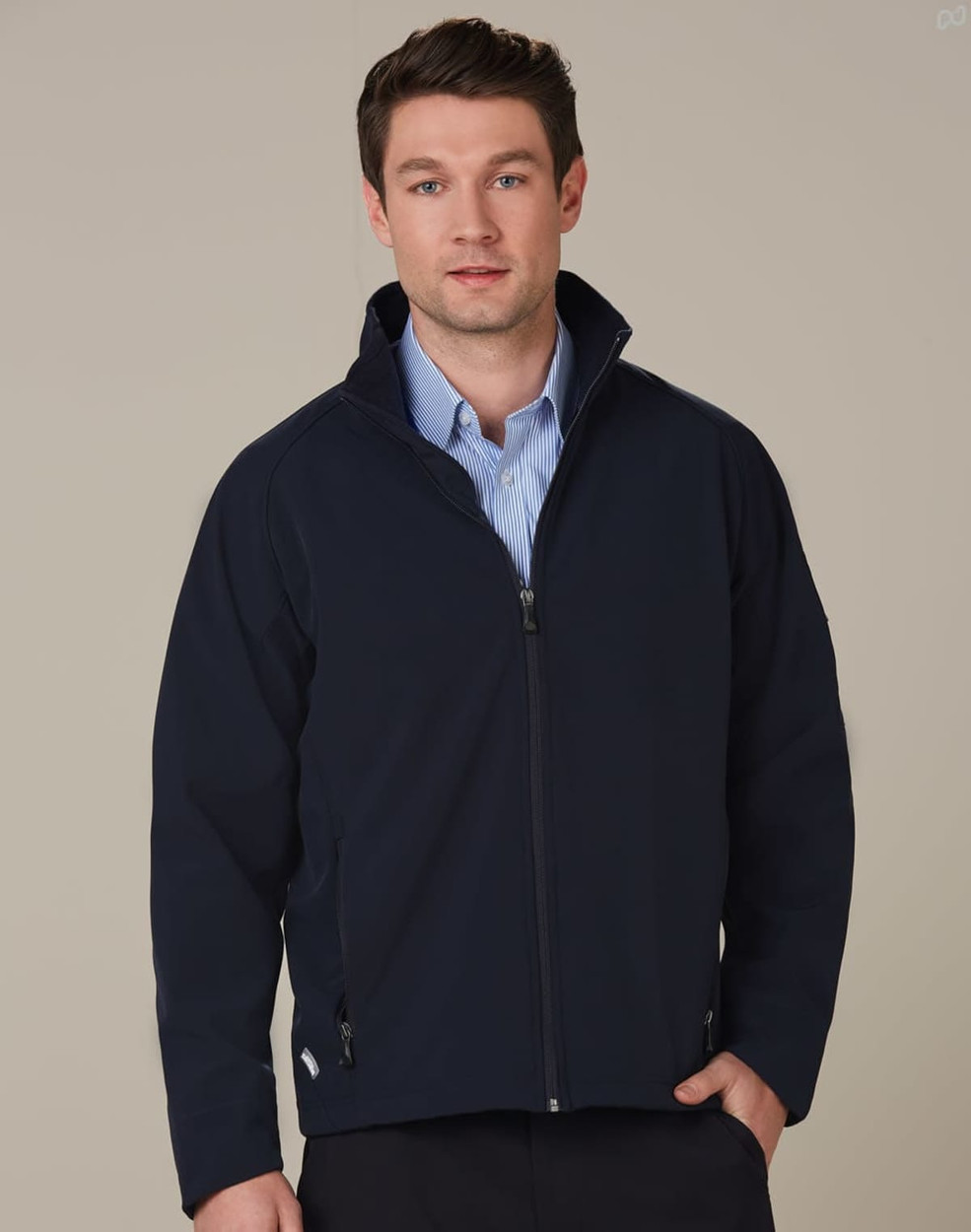 A navy high-tech softshell jacket with a zip front, featuring a collar and side pockets, worn by a model.