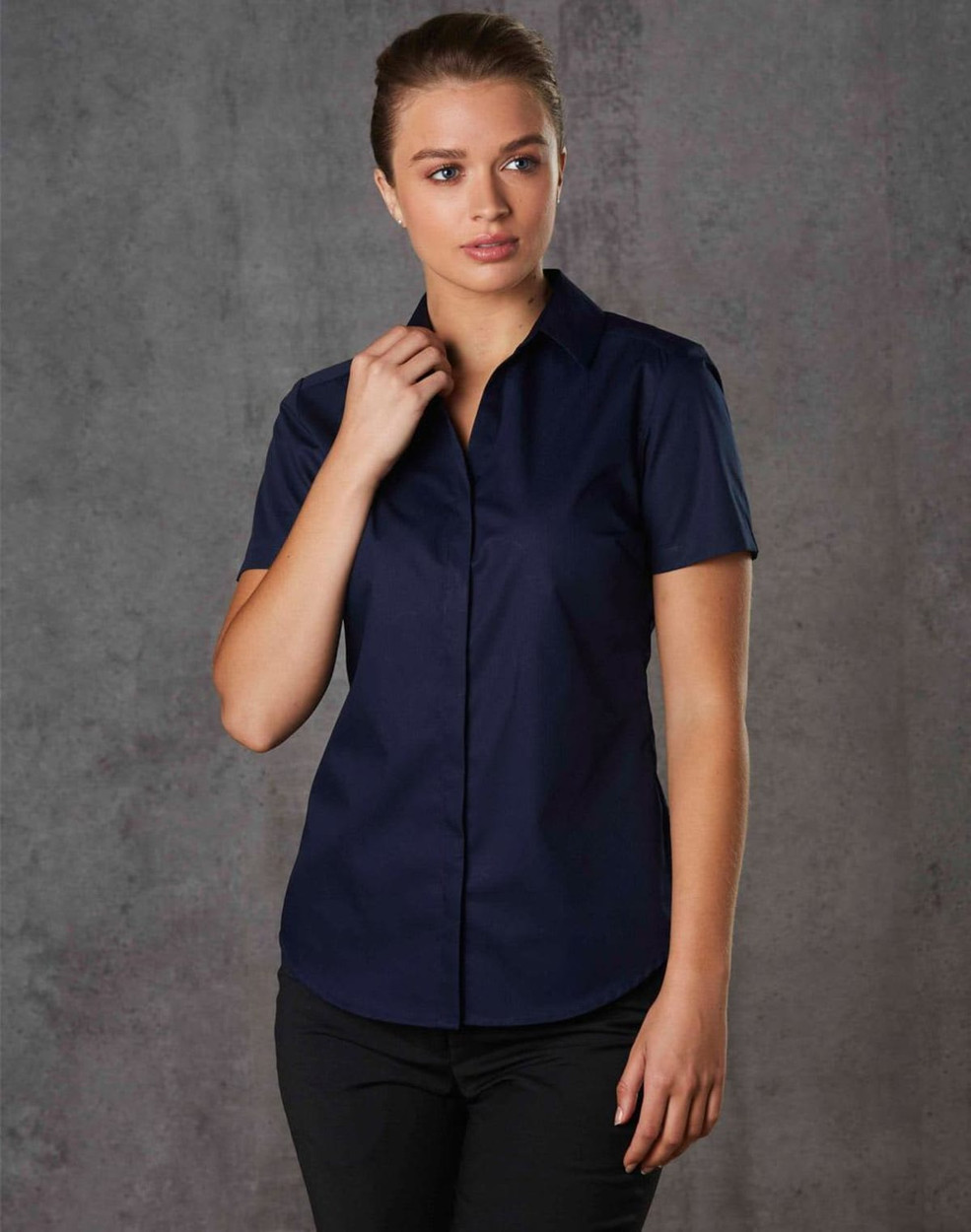 A navy blue short-sleeved button-up shirt for women, featuring a sleek design and a subtle texture.