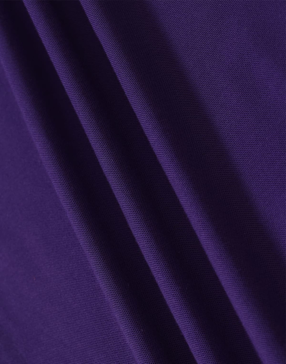 A close-up of fabric in a rich purple hue, showcasing the texture and depth of the material.