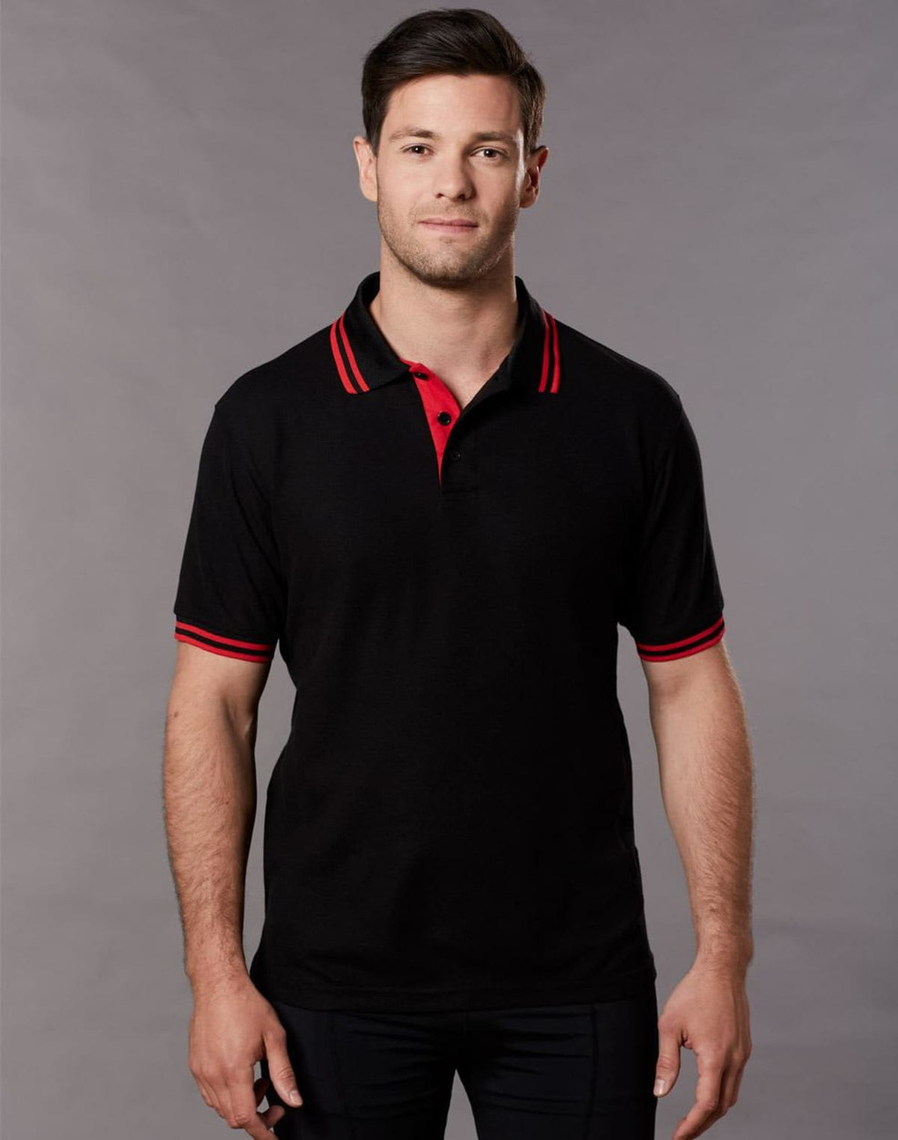 A black polo shirt with red collar and sleeve stripes, featuring a logo on the chest.