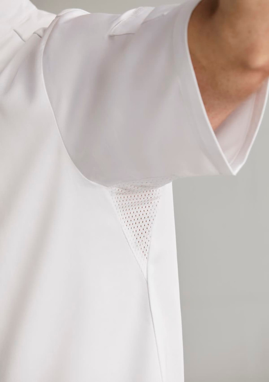 A white short sleeve chef jacket featuring mesh underarm panels and a logo.