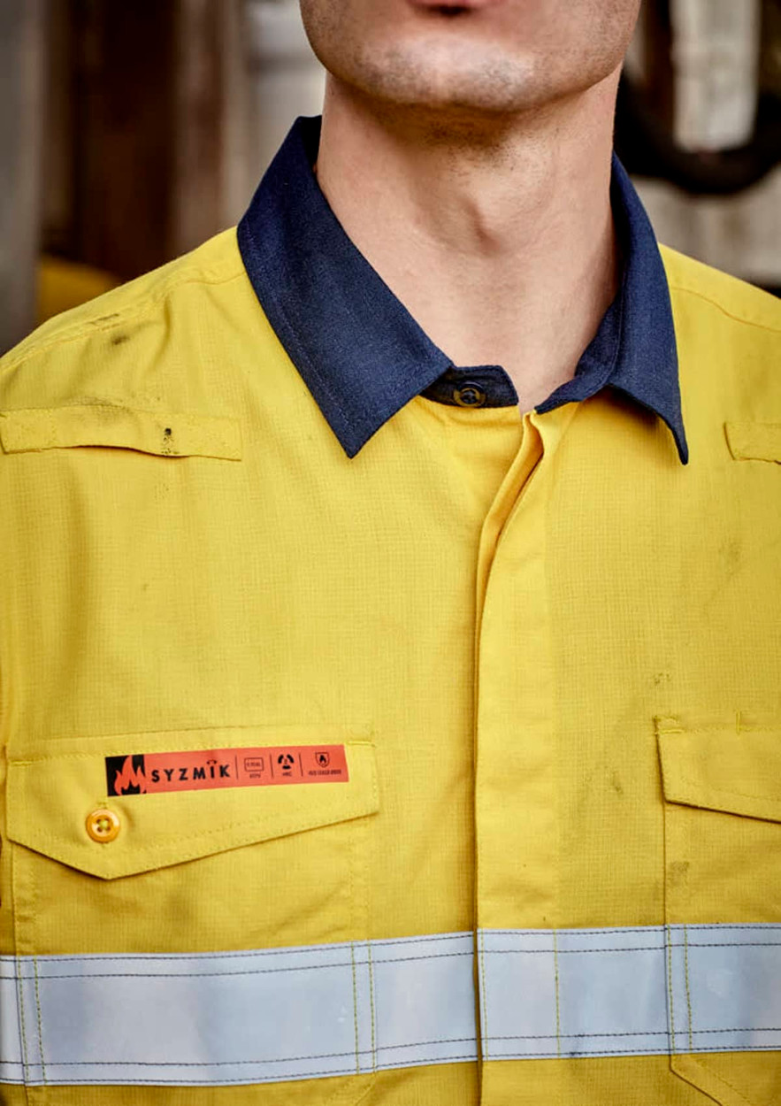 A yellow and navy work shirt with reflective hoop tape and a logo on the chest.