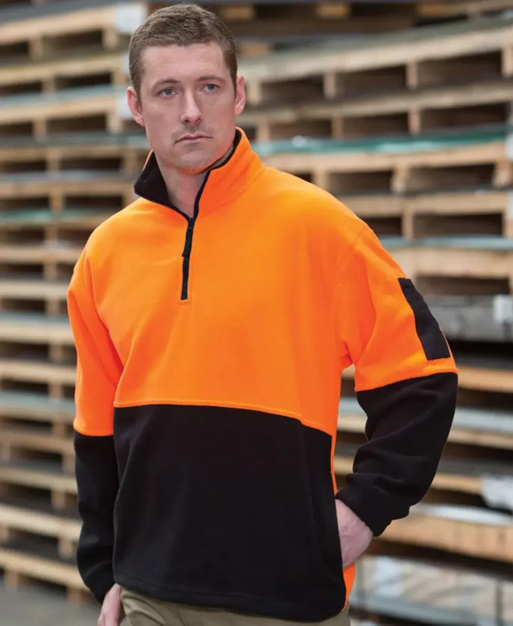 An orange and black polar fleece sweatshirt with a half-zip collar and a logo on the chest.