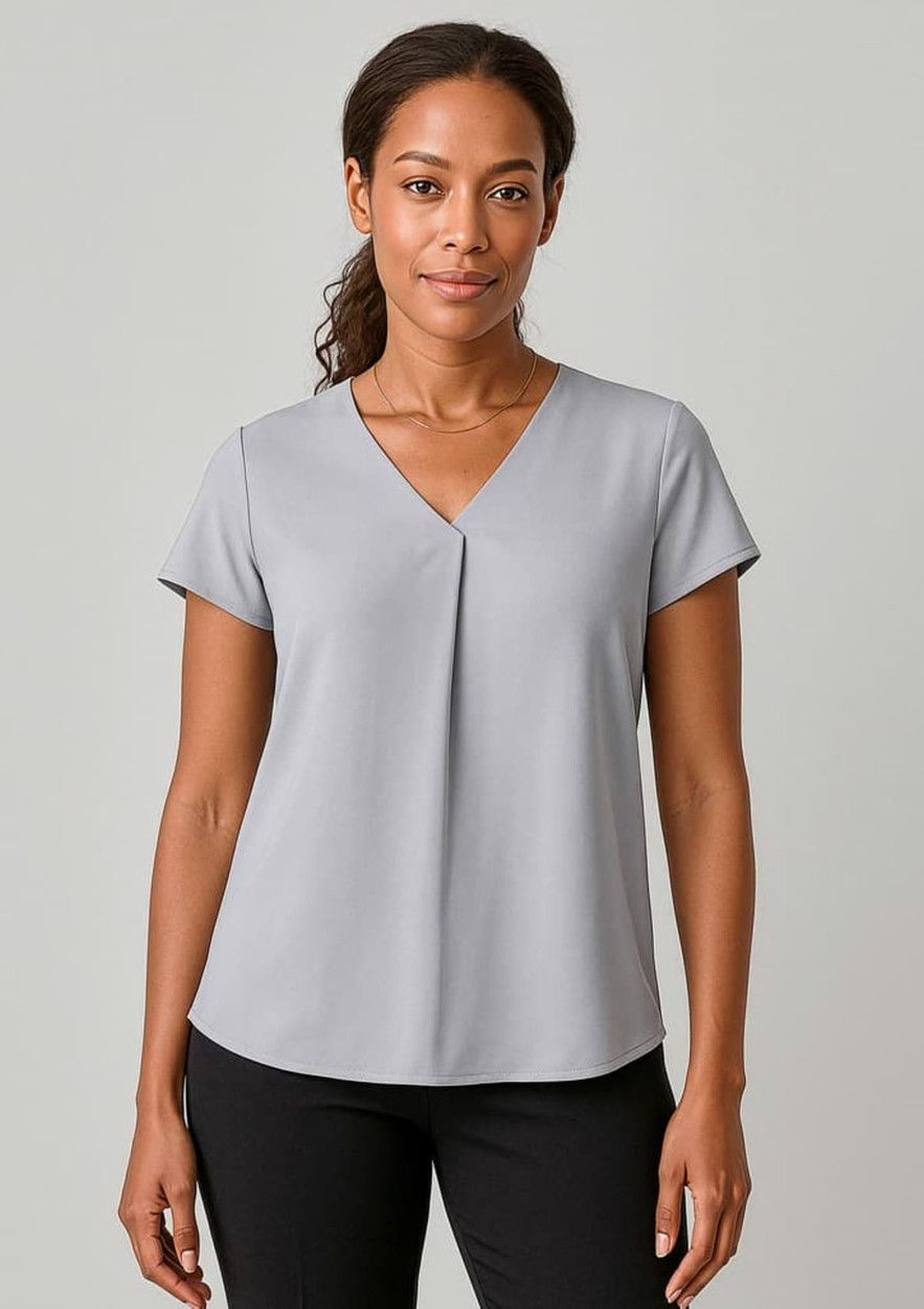 A grey women's blouse featuring a V-neck and pleat design, paired with black trousers, presented on a model.
