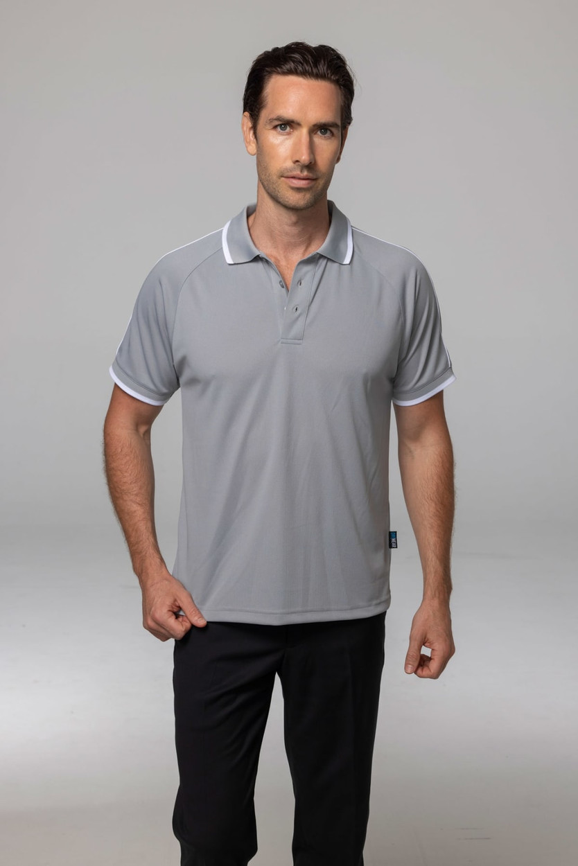 A man wearing a grey polo shirt with white accents, standing against a neutral background. The shirt has a logo.