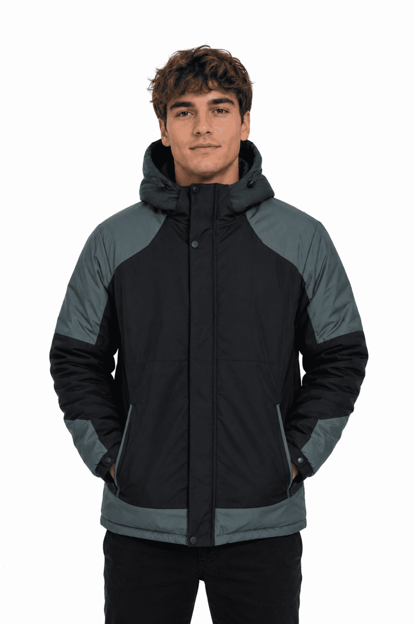 A man wearing a black and grey jacket with a hood, featuring a zip front and side pockets.