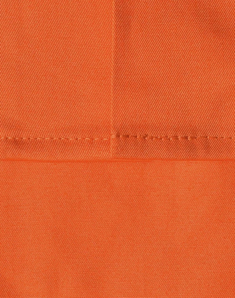 An orange fabric swatch featuring a close-up of stitching details, ideal for workwear applications.