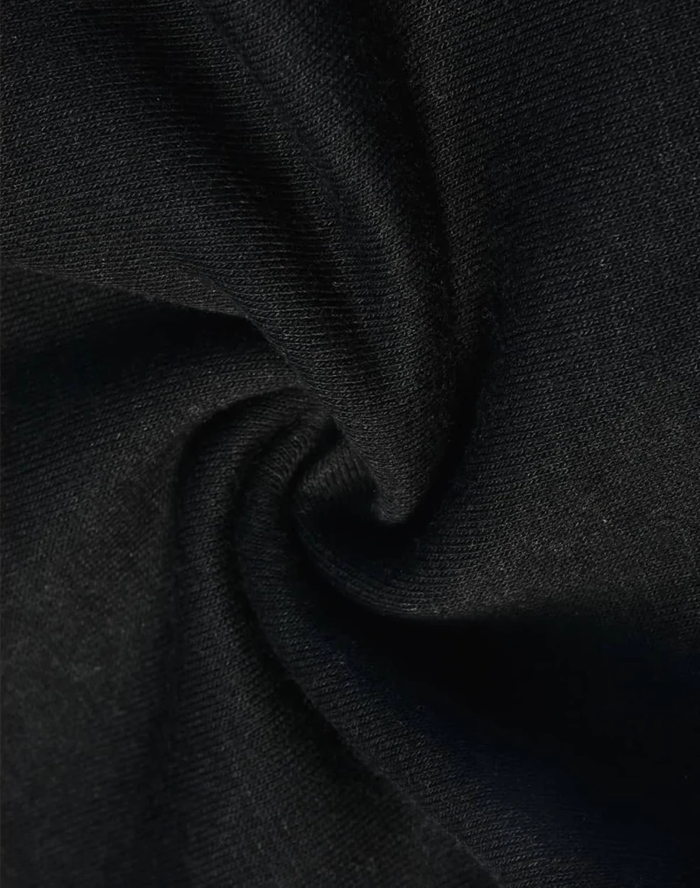 A close-up of black poly/cotton fabric, featuring a soft and smooth texture suitable for sweat pants.