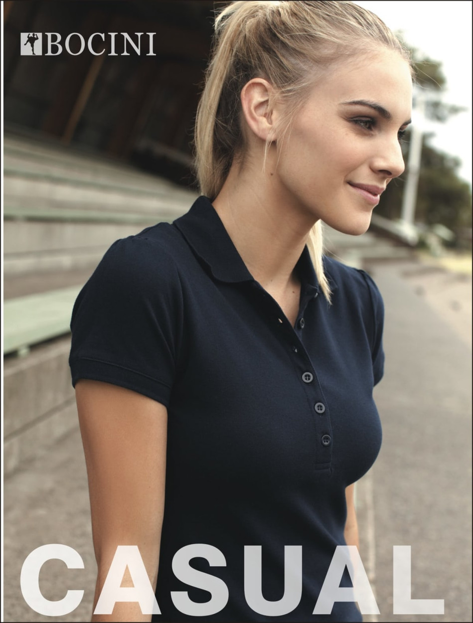 A navy Ladies Fashion Polo shirt with a fitted design and a logo. The model has a ponytail and casual pose.