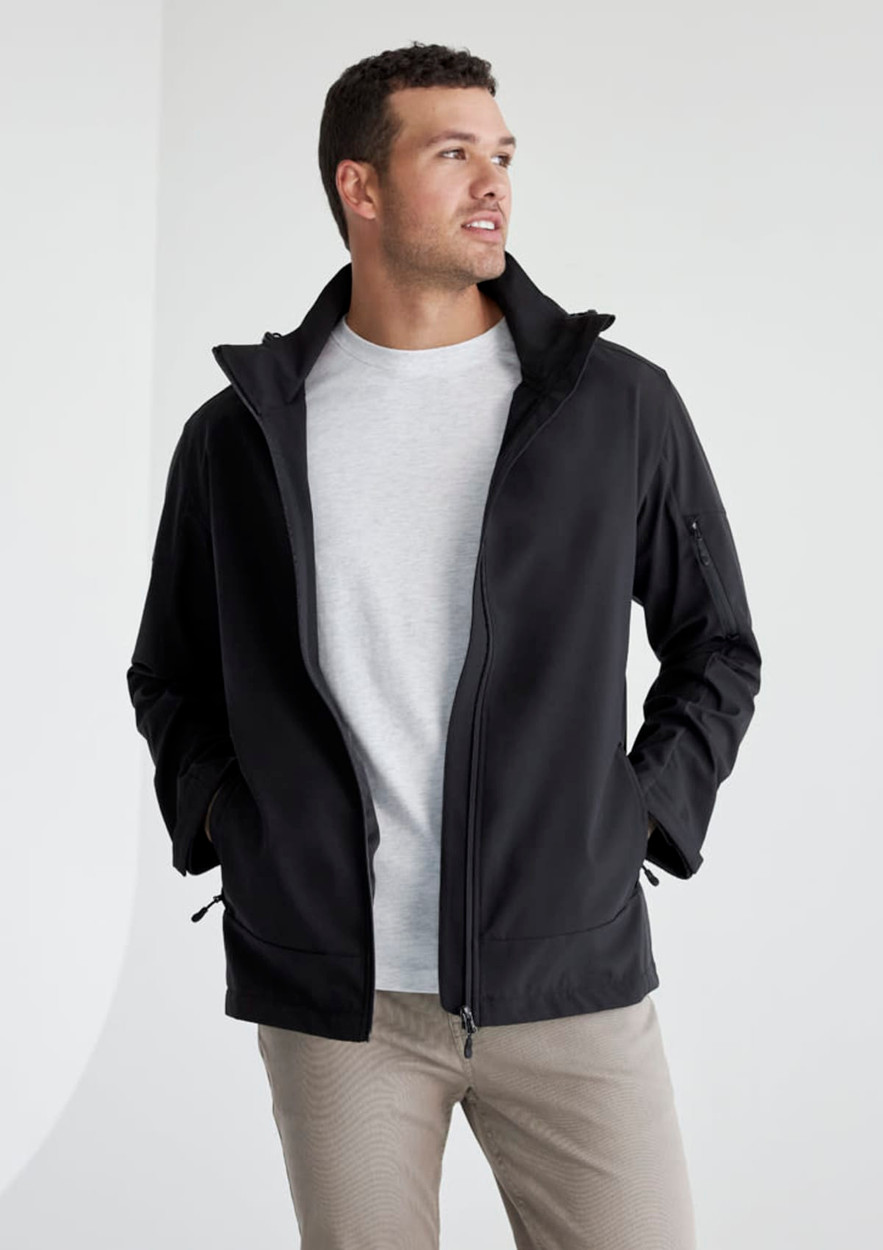 A man wearing a black rain jacket with a grey shirt underneath. The jacket has a logo on it.