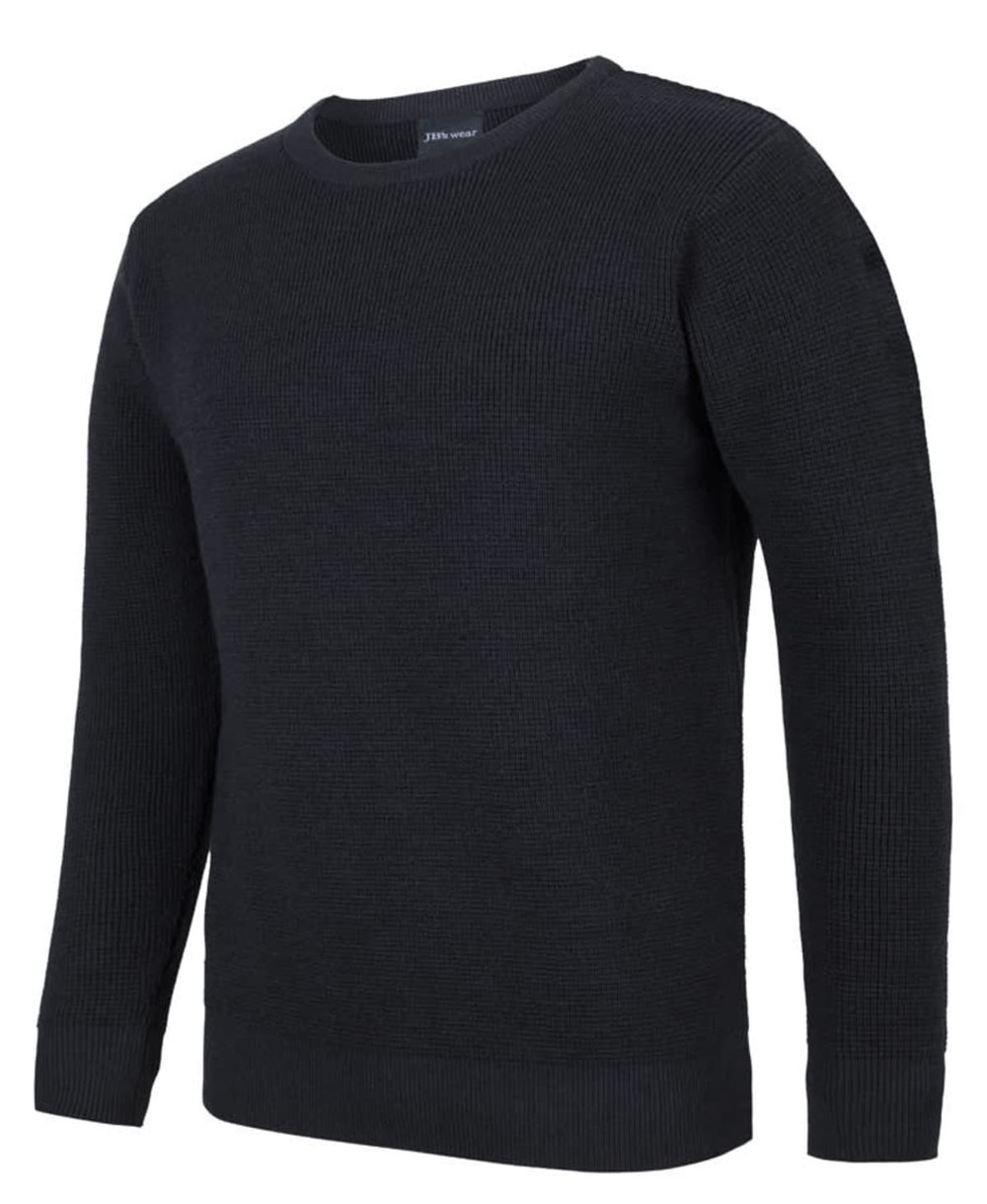 A black knitted crew neck jumper with long sleeves and ribbed detailing. It features a branding logo on the neck.