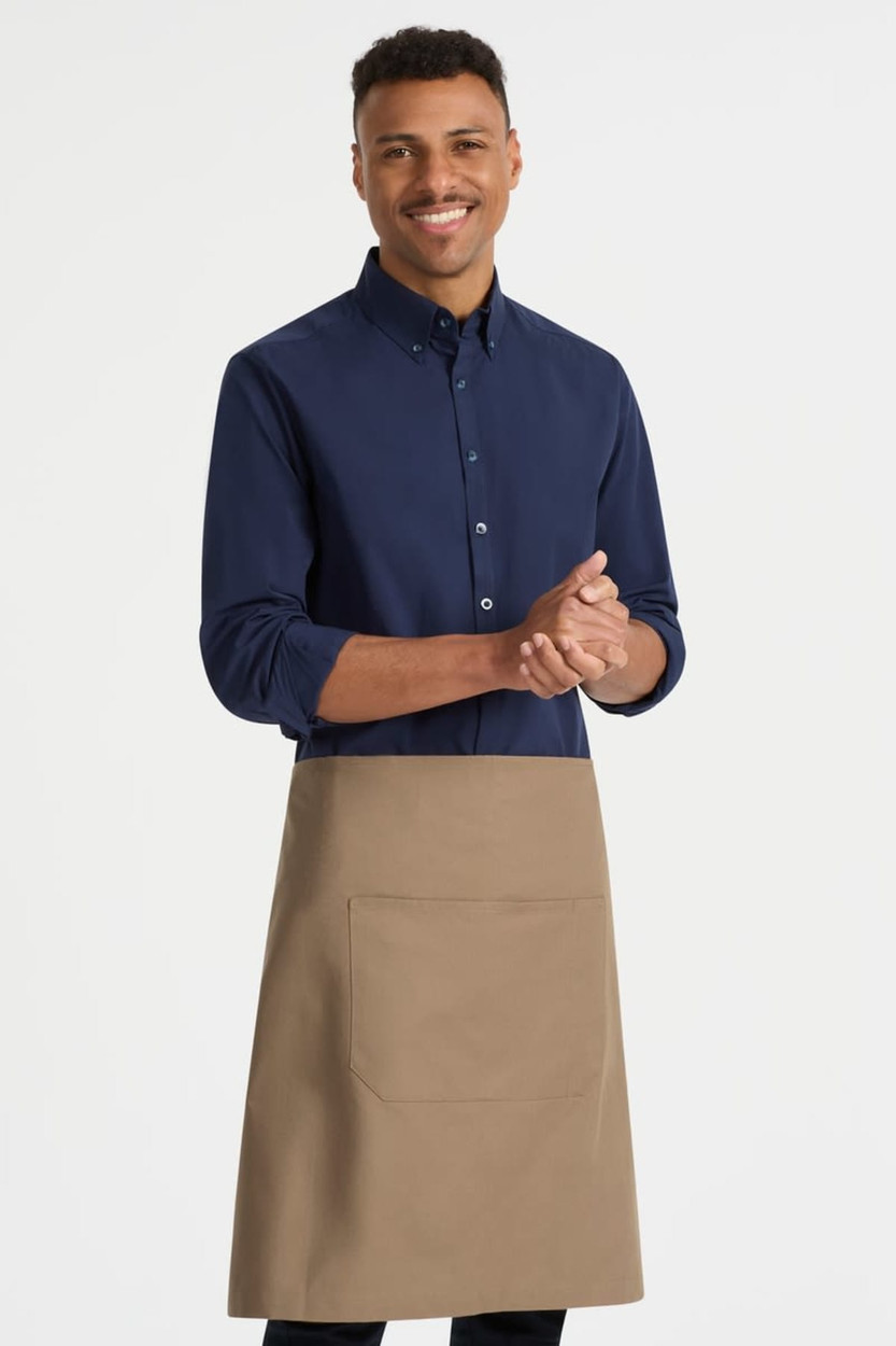 A man wearing a navy shirt and a beige waist apron with a front pocket. The apron features a branding logo.