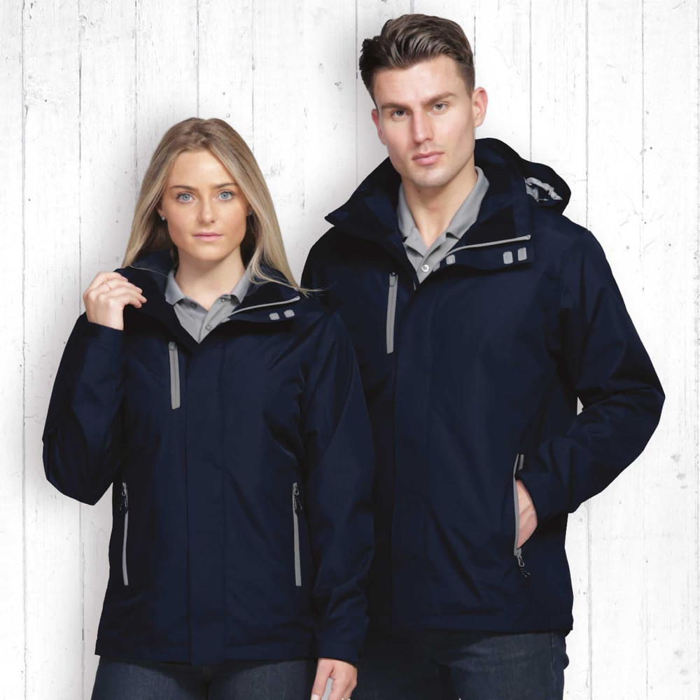 A navy soft shell jacket on a man and woman, featuring zippered pockets and a hood. The background is wooden.