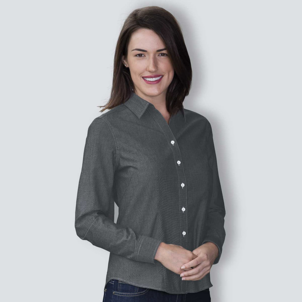 A woman wearing a dark grey button-up chambray shirt with a collar and white buttons.