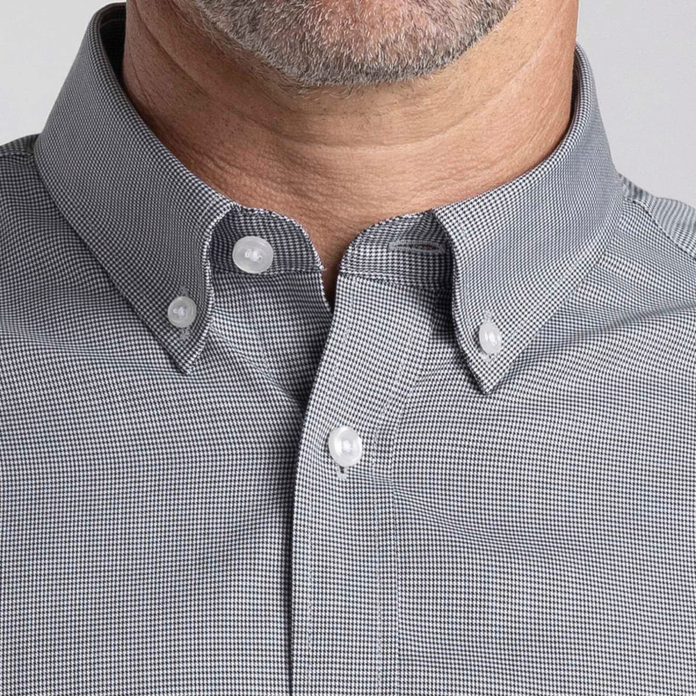 A close-up of a men's button-up shirt featuring a grey checked pattern and a button-down collar. Includes branding.