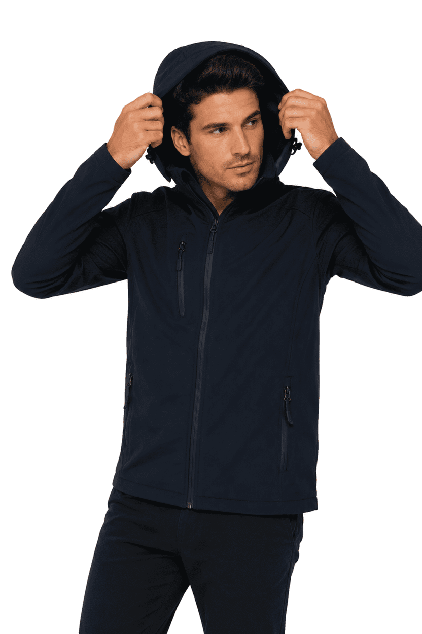 A man wearing a navy soft shell jacket with a hood, featuring zippered pockets and a fitted design.