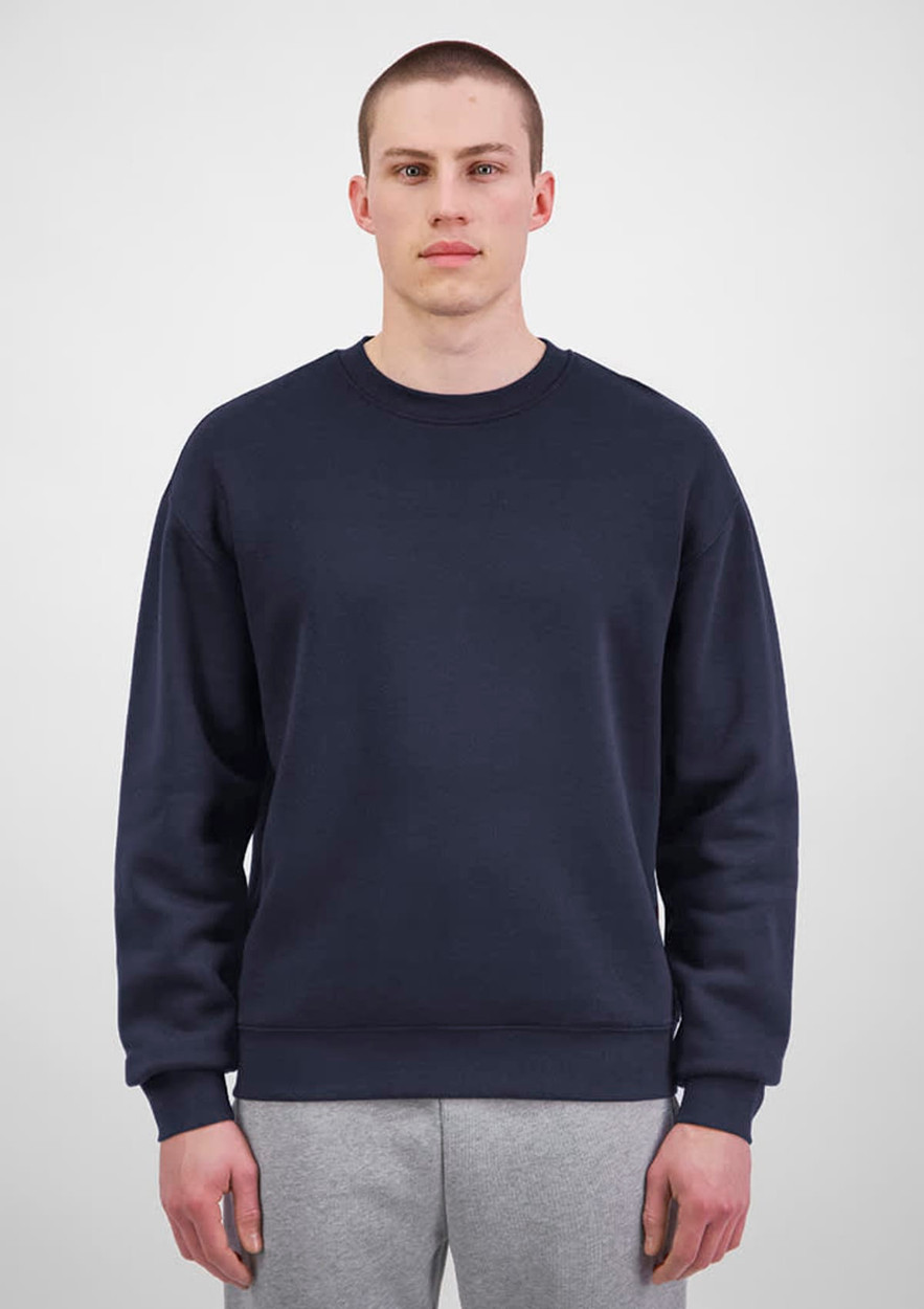 A navy blue men's crew sweatshirt displayed on a model, featuring a simple design and equipped with a logo.