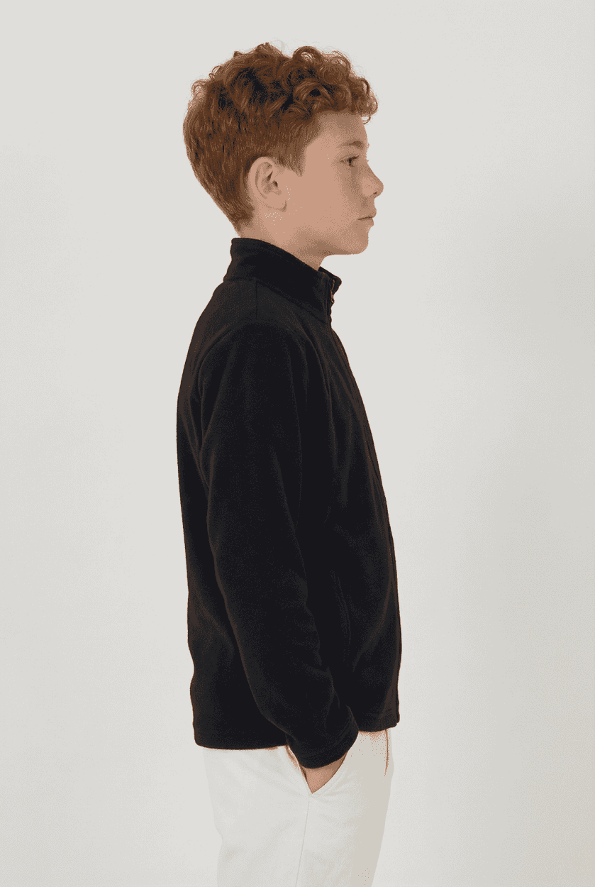 A black youth polar fleece full zip jacket shown worn by a child in profile. Features a collar and long sleeves.