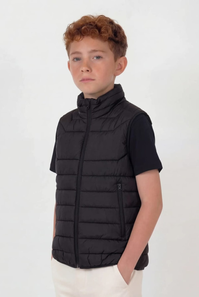 A black puffer vest with a zip front and side pockets, worn by a young model.