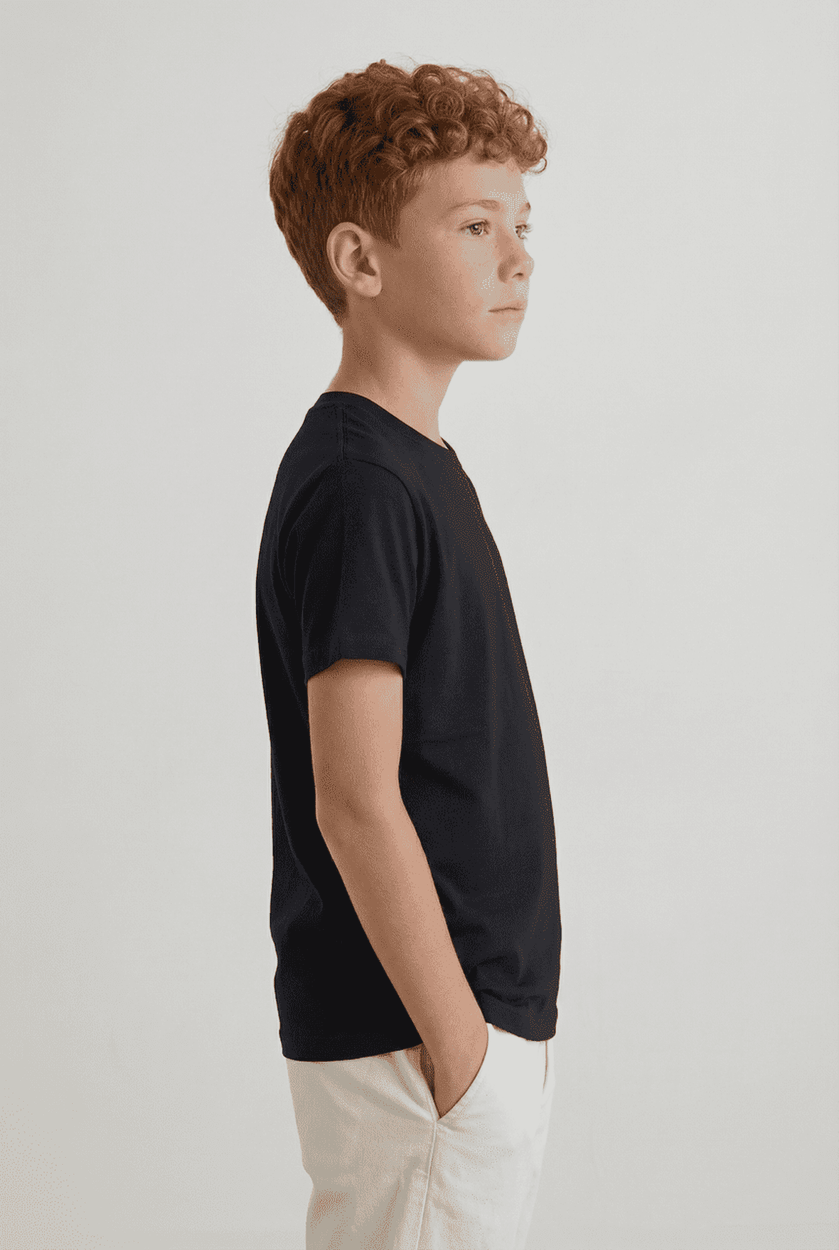 A black youth t-shirt worn by a boy with red hair, standing in profile against a plain background.