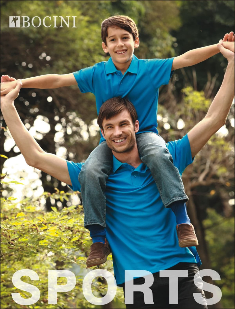 A man and a boy wear matching blue polo shirts, with the boy sitting on the man's shoulders in an outdoor setting.