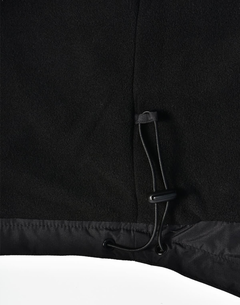 A close-up of the bottom hem of a black unisex jacket featuring a drawstring adjustment.