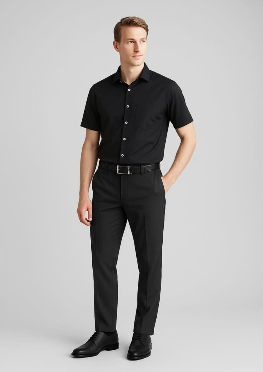 A pair of black slimline pants made of wool stretch, modelled by a man in a black short-sleeve shirt and belt.