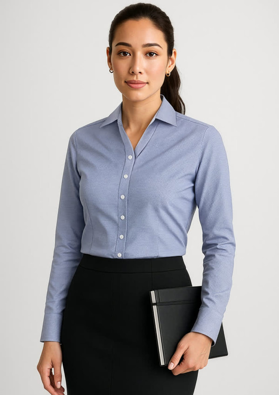 A long sleeve, button-up shirt in light blue, featuring a slim fit and a logo. Suitable for formal attire.