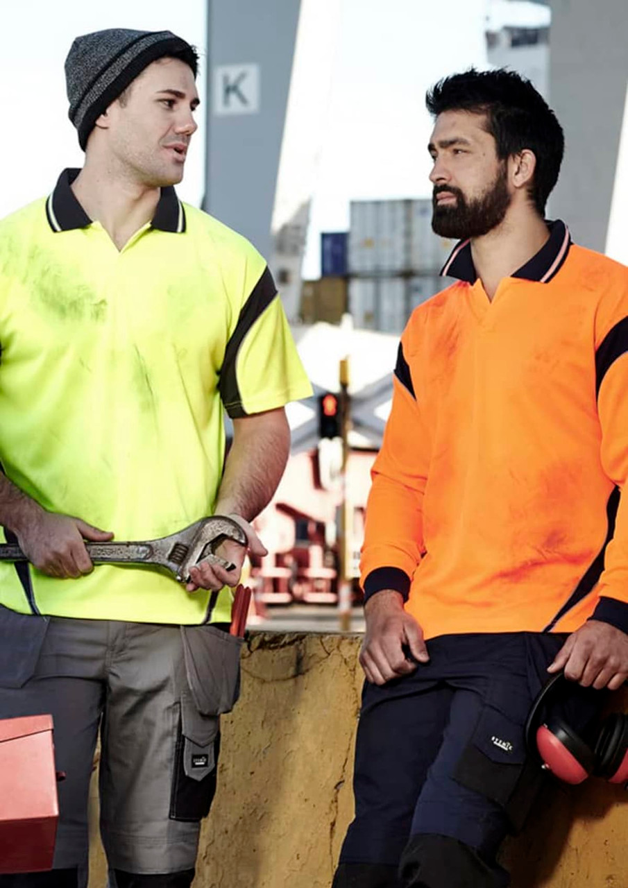 Two men in high visibility polo shirts, one in yellow and the other in orange, in a work environment.