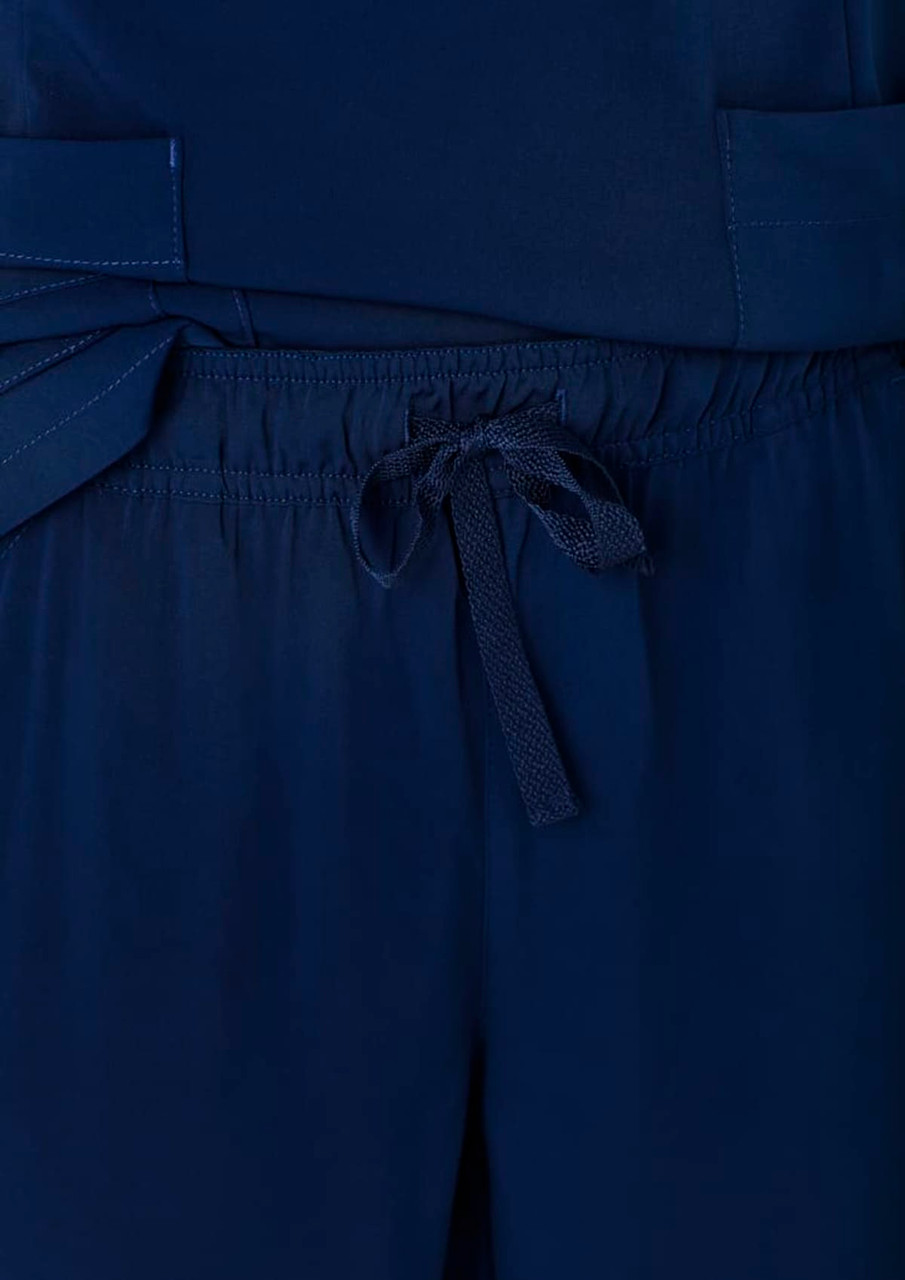 Navy blue women's straight leg scrub pants featuring a drawstring waist and pockets. Branding is present on the fabric.