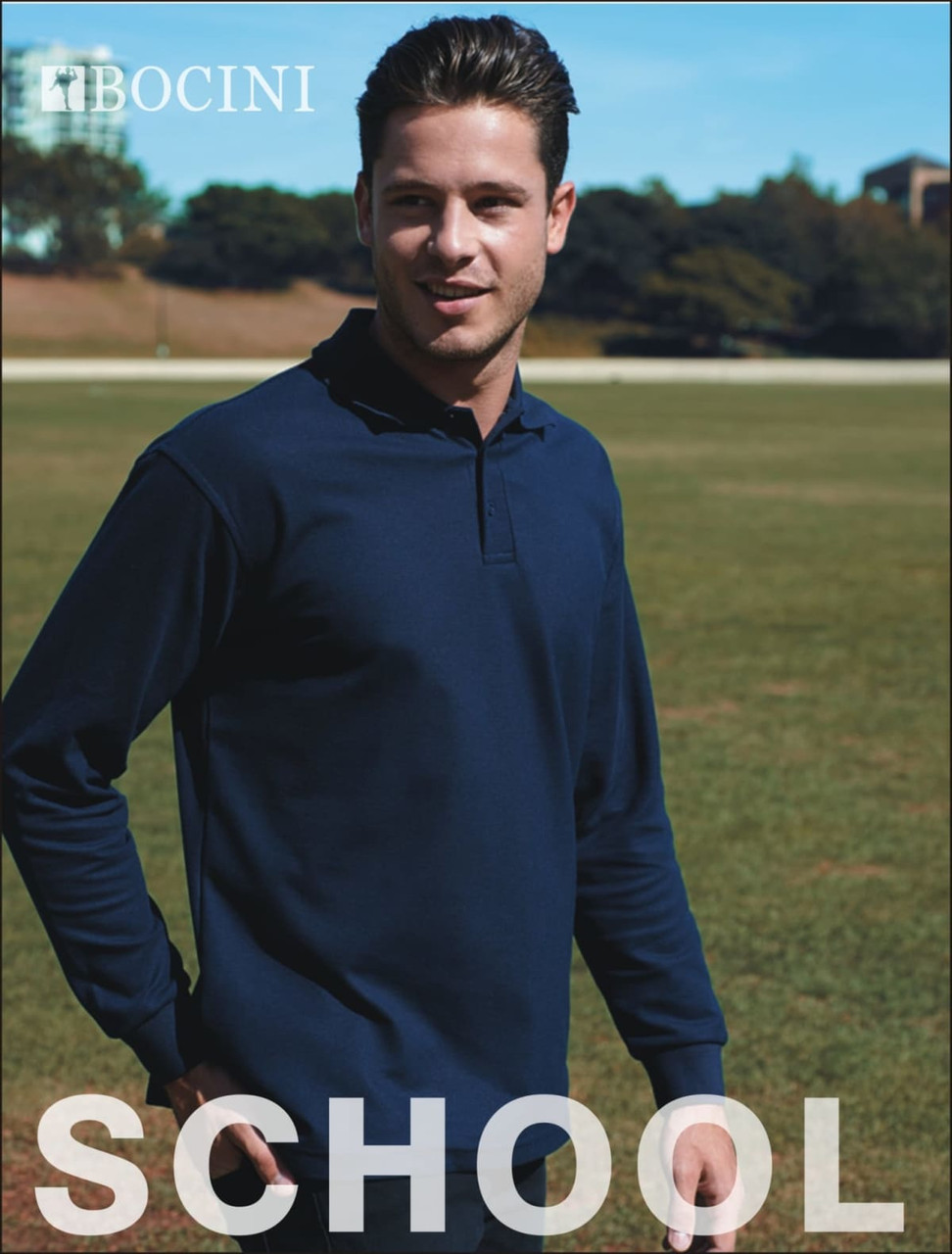 A navy long sleeve polo shirt with a collar, featuring a logo on the left side. The model is outdoors on grassy terrain.