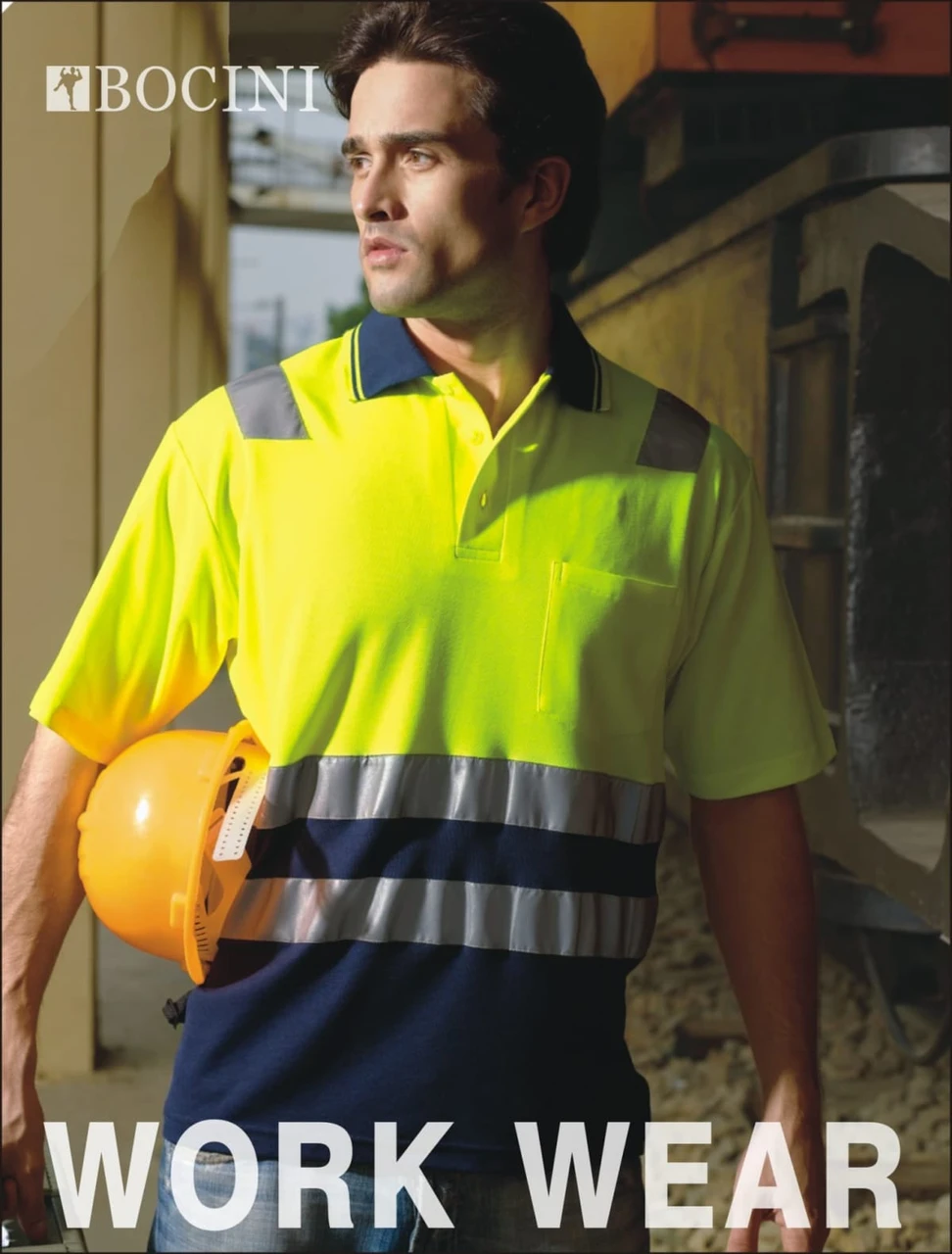 A bright yellow and navy unisex polo shirt featuring 3M reflective tape and a logo, modelled by a man on a worksite.