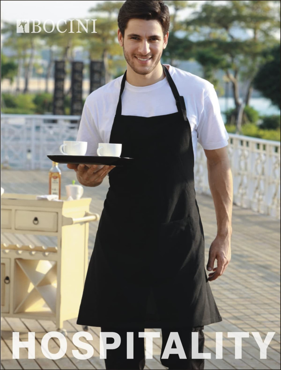 A black polyester drill full bib apron with a pocket, worn by a man holding a tray with two cups.