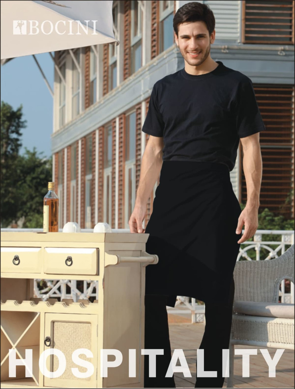 A man wearing a black polyester drill half apron stands by a table outside, featuring a logo on the apron.