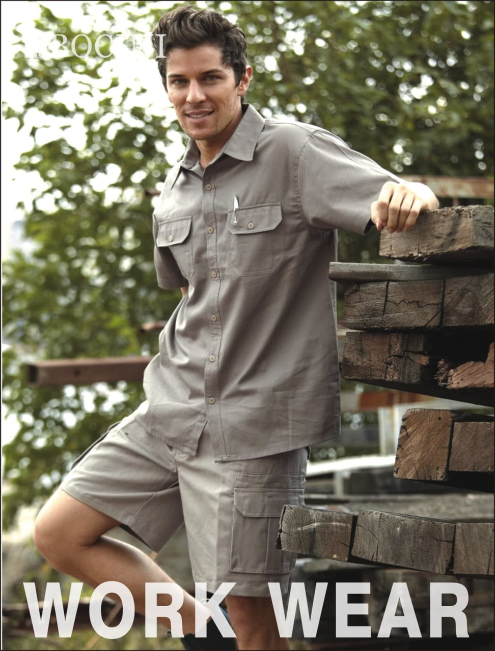 A short-sleeved unisex cotton drill work shirt in grey, featuring a pocket and a logo, displayed on a model.