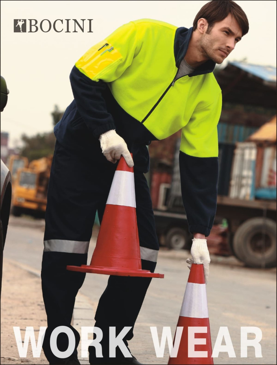 A model wearing a bright yellow and black high-visibility polar fleece jacket, holding traffic cones. The garment features a logo.