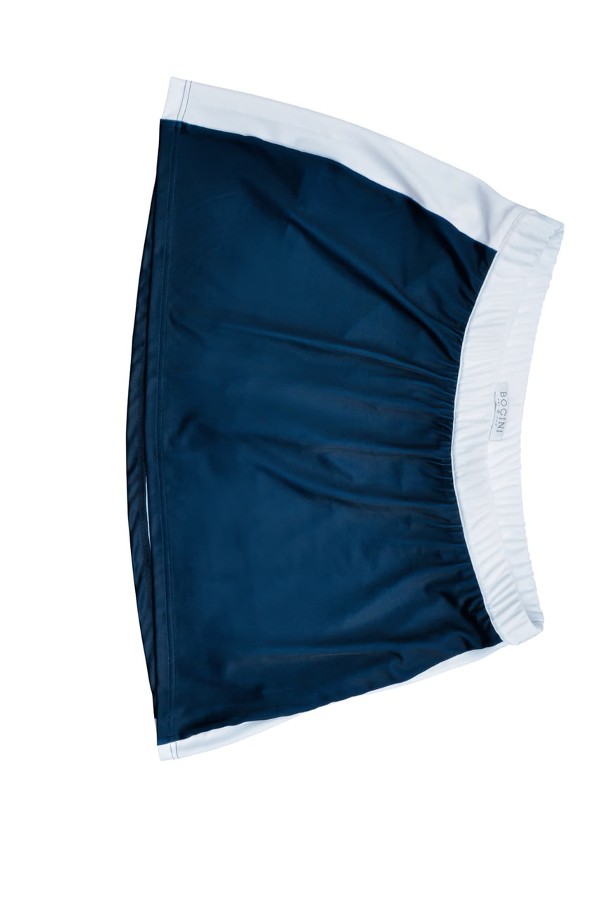 A navy and white ladies sports skort with an elastic waistband and a branded logo.