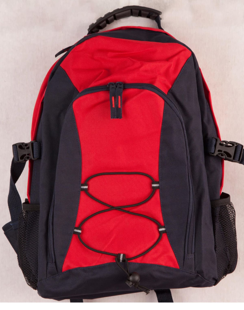 A red and navy Smartpack Backpack featuring adjustable straps and a front bungee cord. It includes side mesh pockets and a logo.