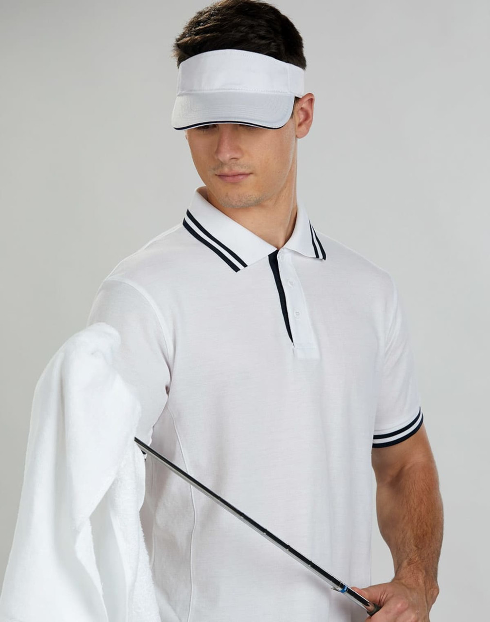 A white contrast sandwich visor worn by a model, paired with a light polo shirt and holding a golf club and towel.