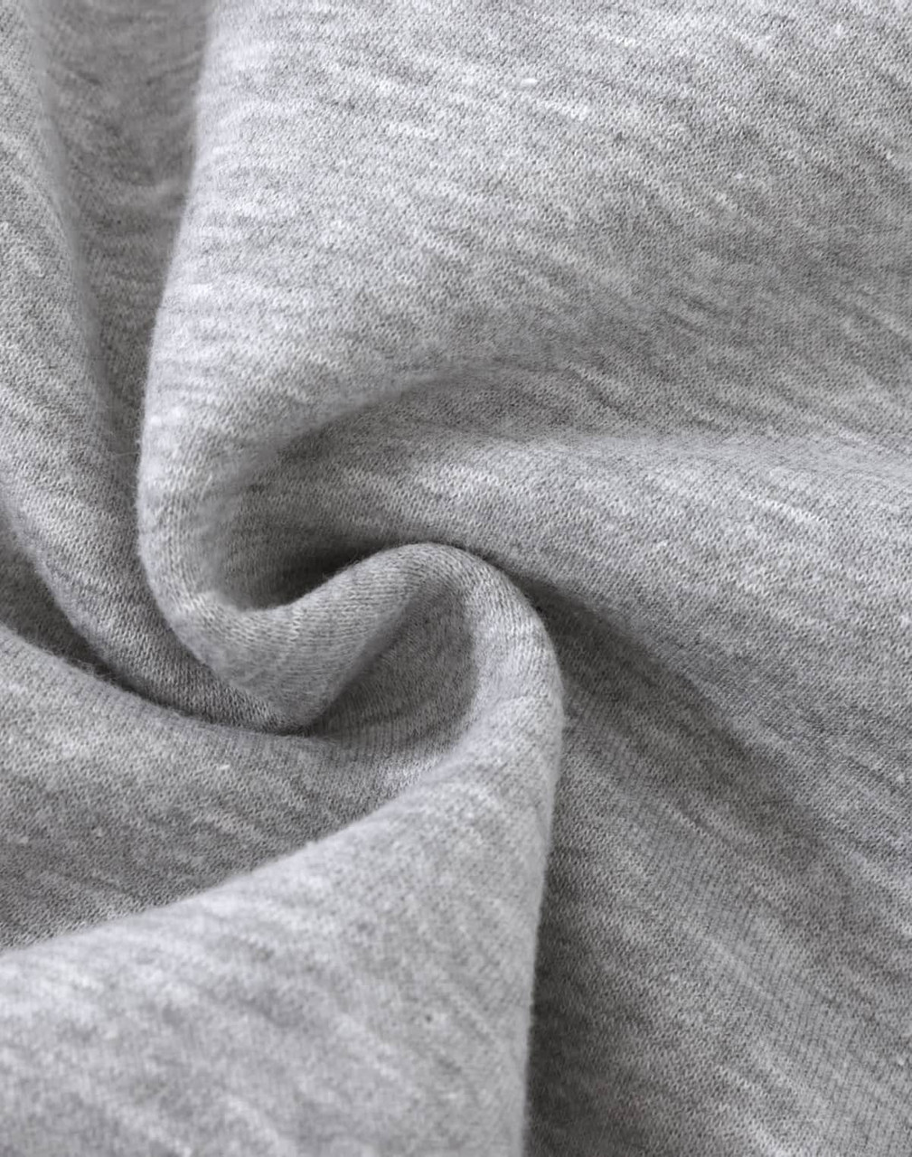 A close-up of soft, grey fabric with a slight texture, typical of a fleece jumper. It features a logo.