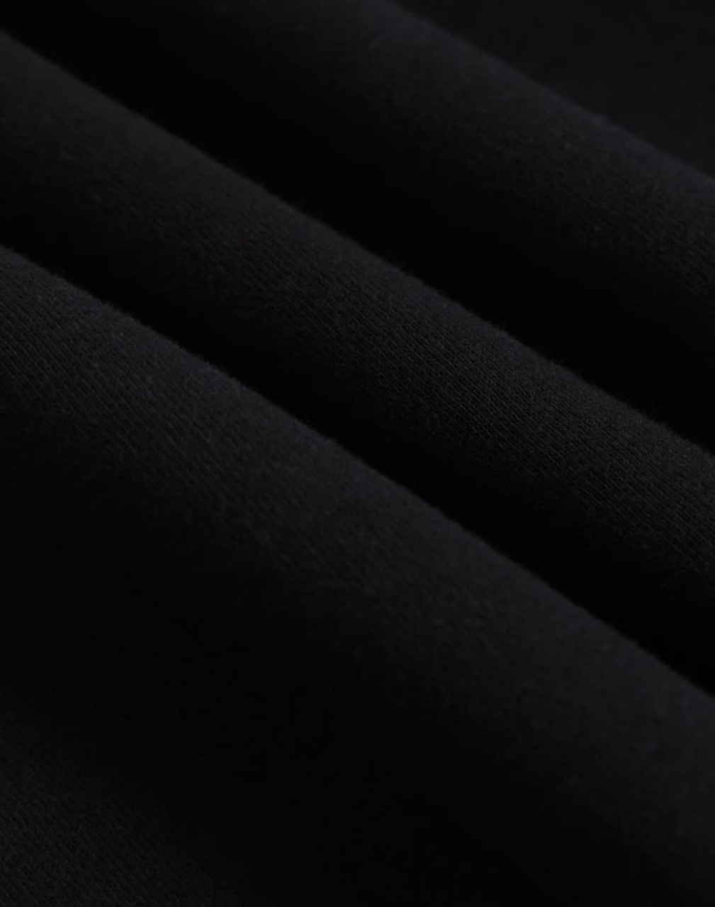 A close-up of black polar fleece fabric, showcasing its soft texture and layering. The image features a logo.