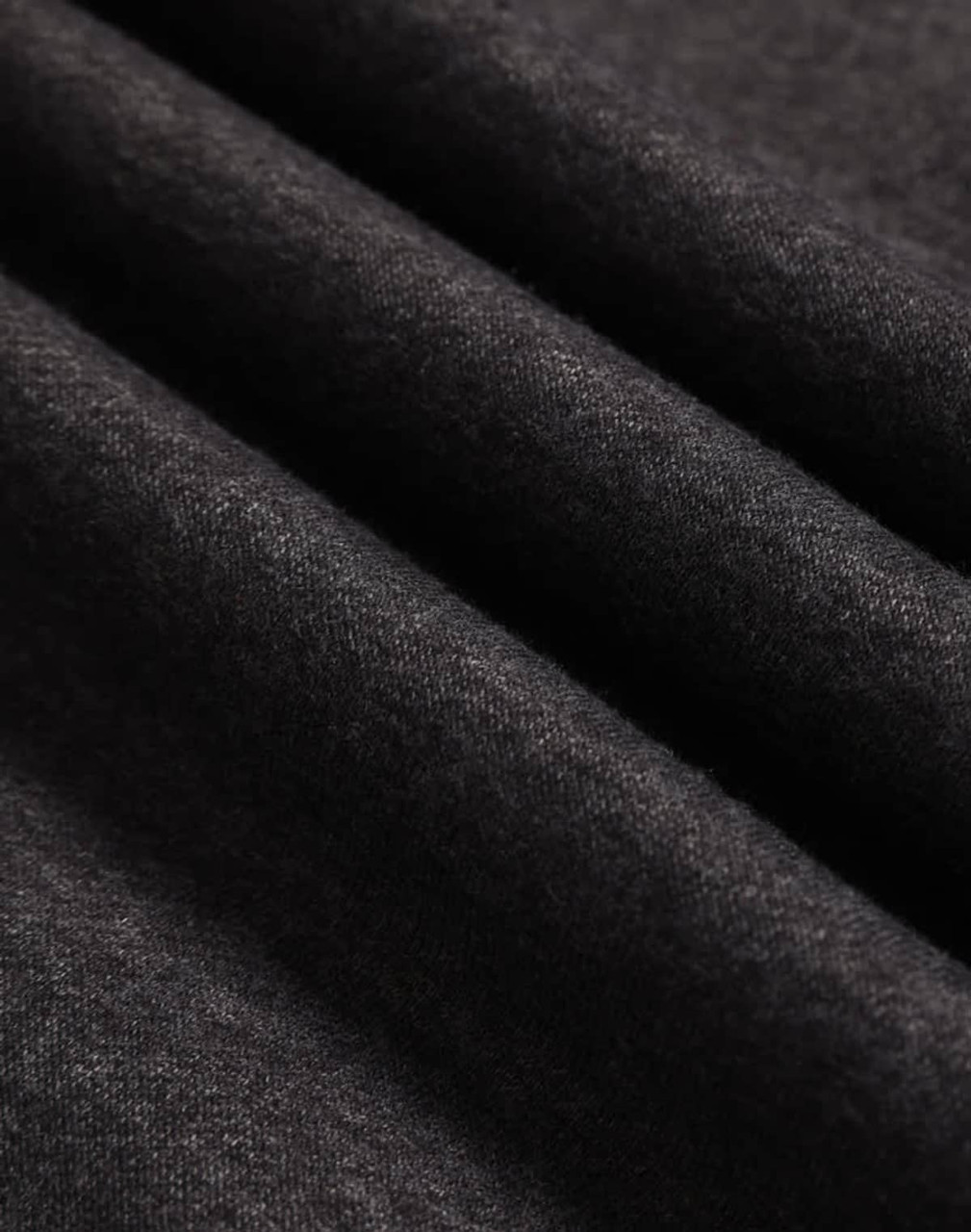 A close-up of dark grey polar fleece fabric with a soft, textured surface.