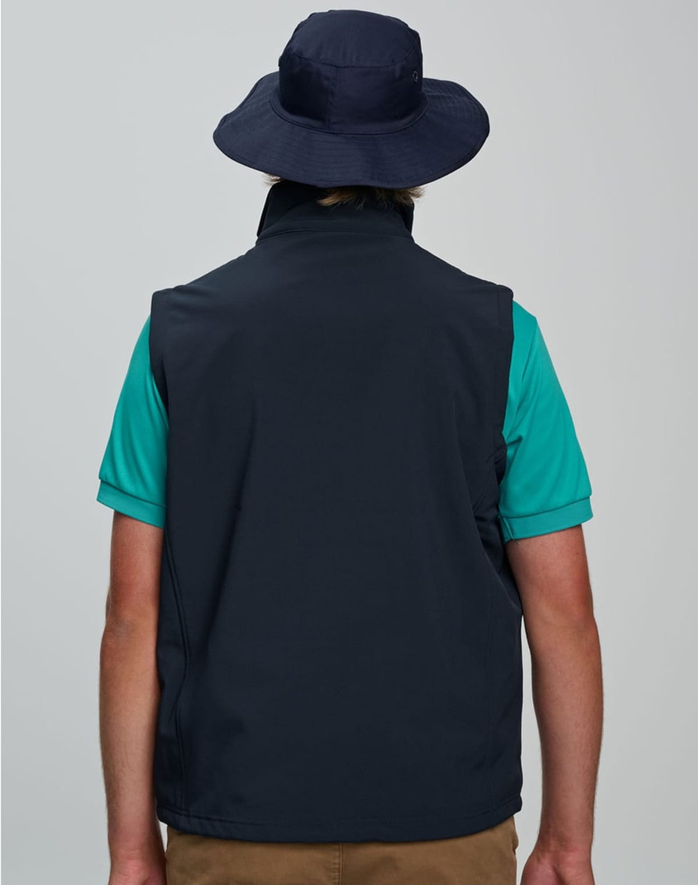 A navy blue surf hat with a clip-on chin strap, worn by a person from the back, paired with a teal shirt.