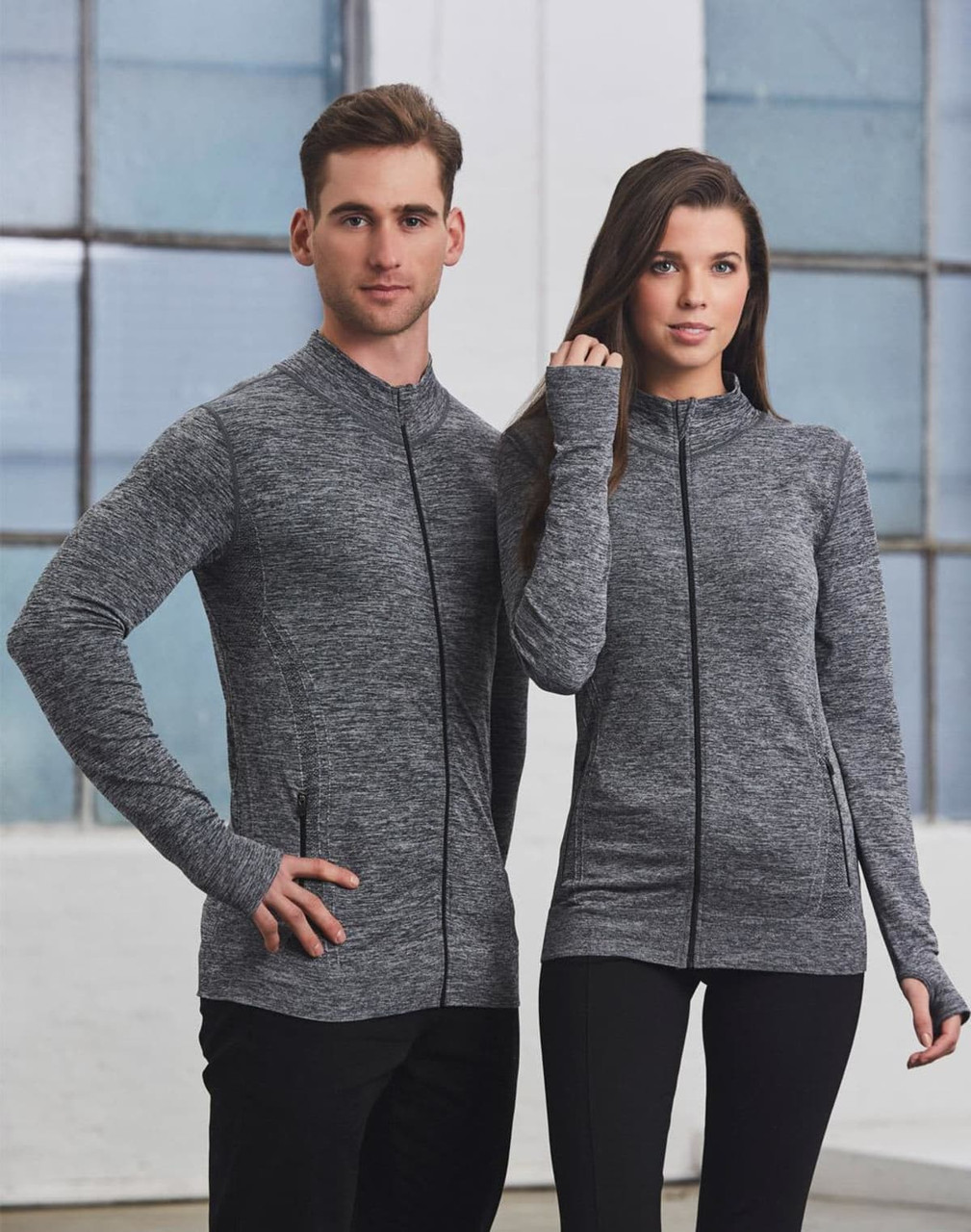 A unisex seamless heather jacket in grey, featuring a zip front and two models standing side by side.