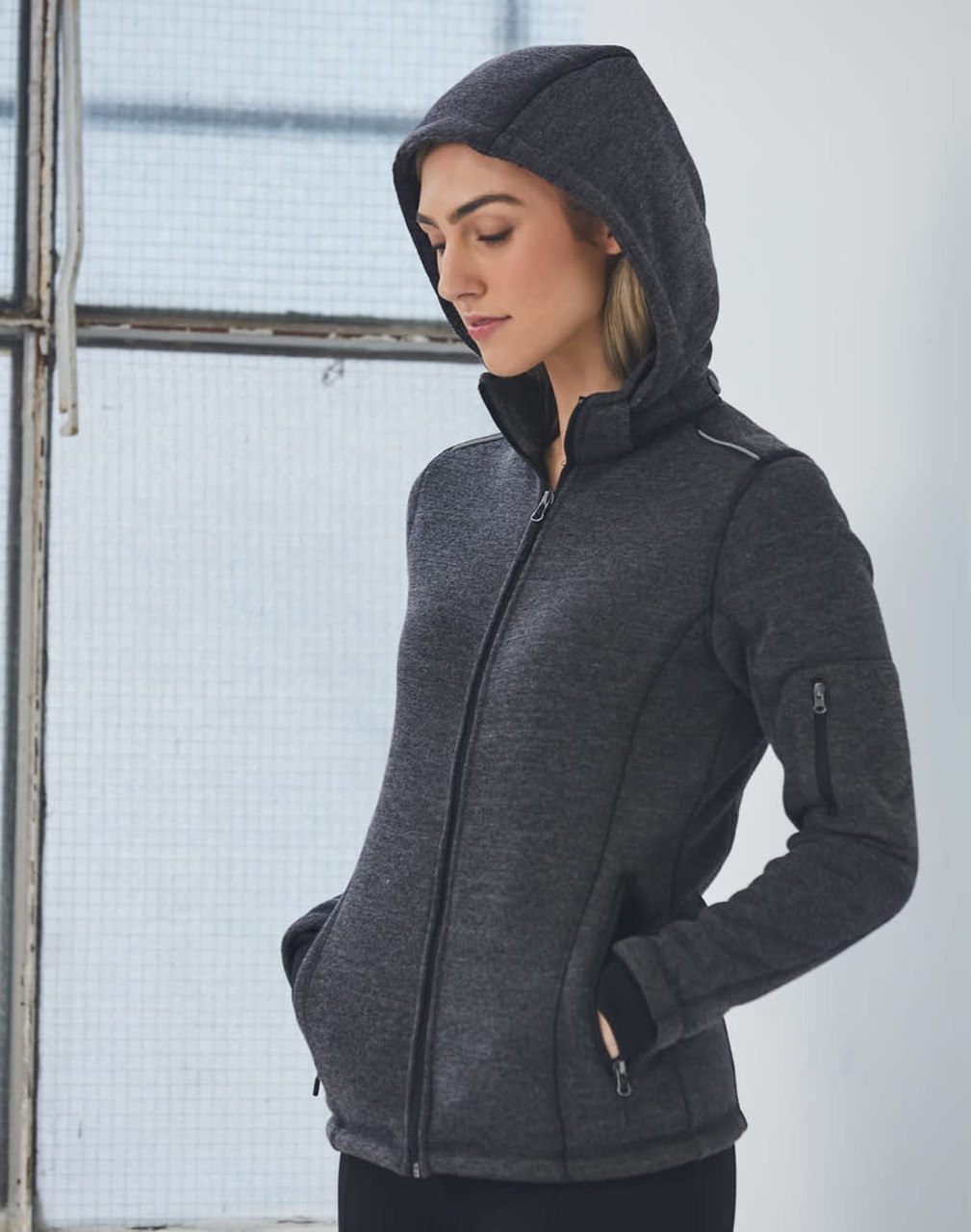 A ladies' heather bonded fleece jacket in dark grey, featuring a zip front and a hood. The jacket has a logo.