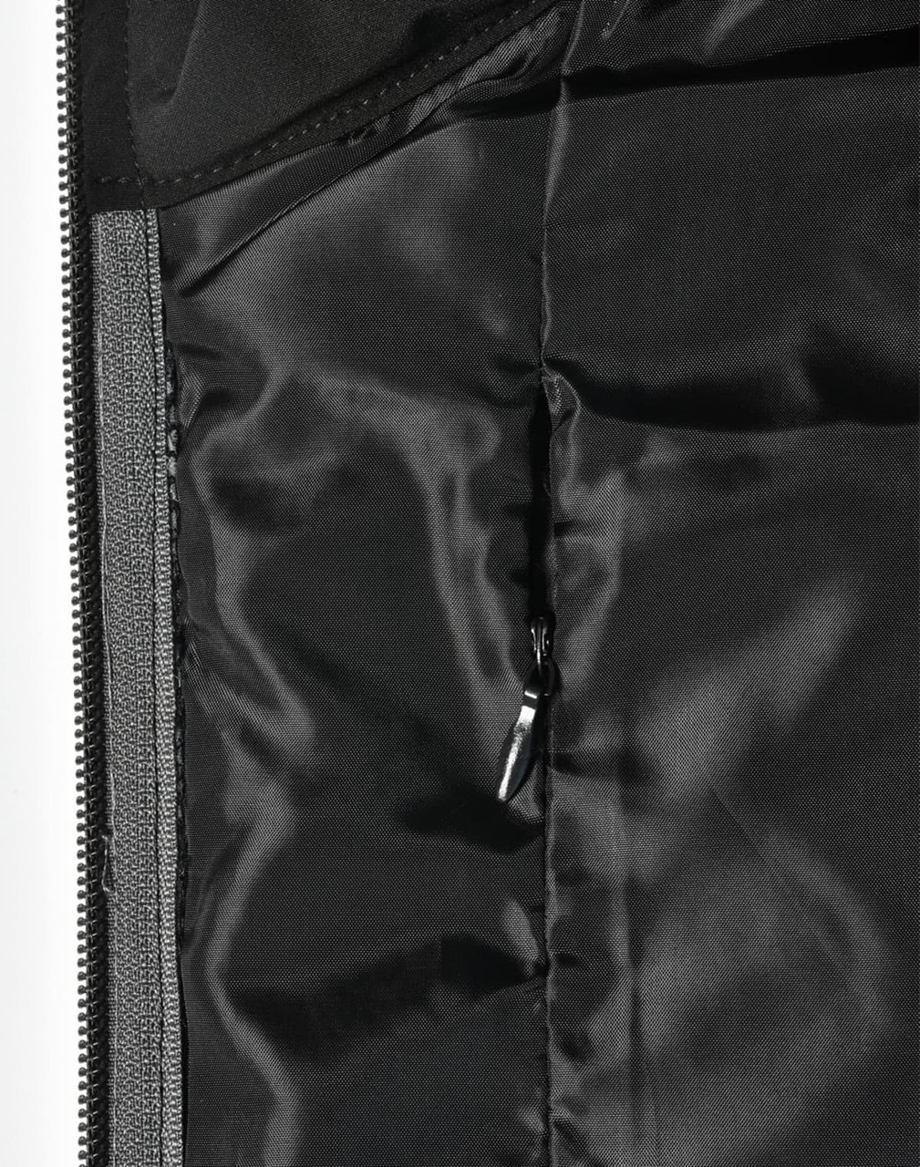 A close-up of a quilted jacket's interior lining in black, featuring a zippered pocket and smooth texture.
