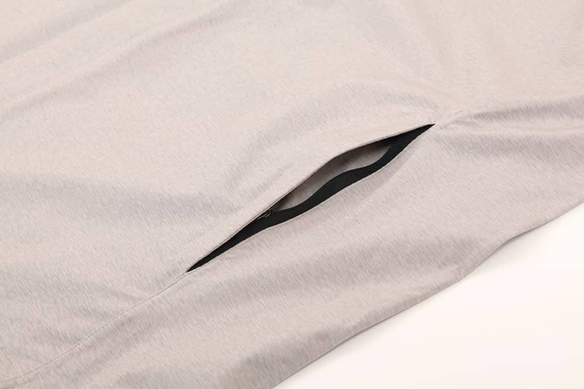 A light grey performance jacket featuring a zipped pocket on the side, designed for waterproof protection.