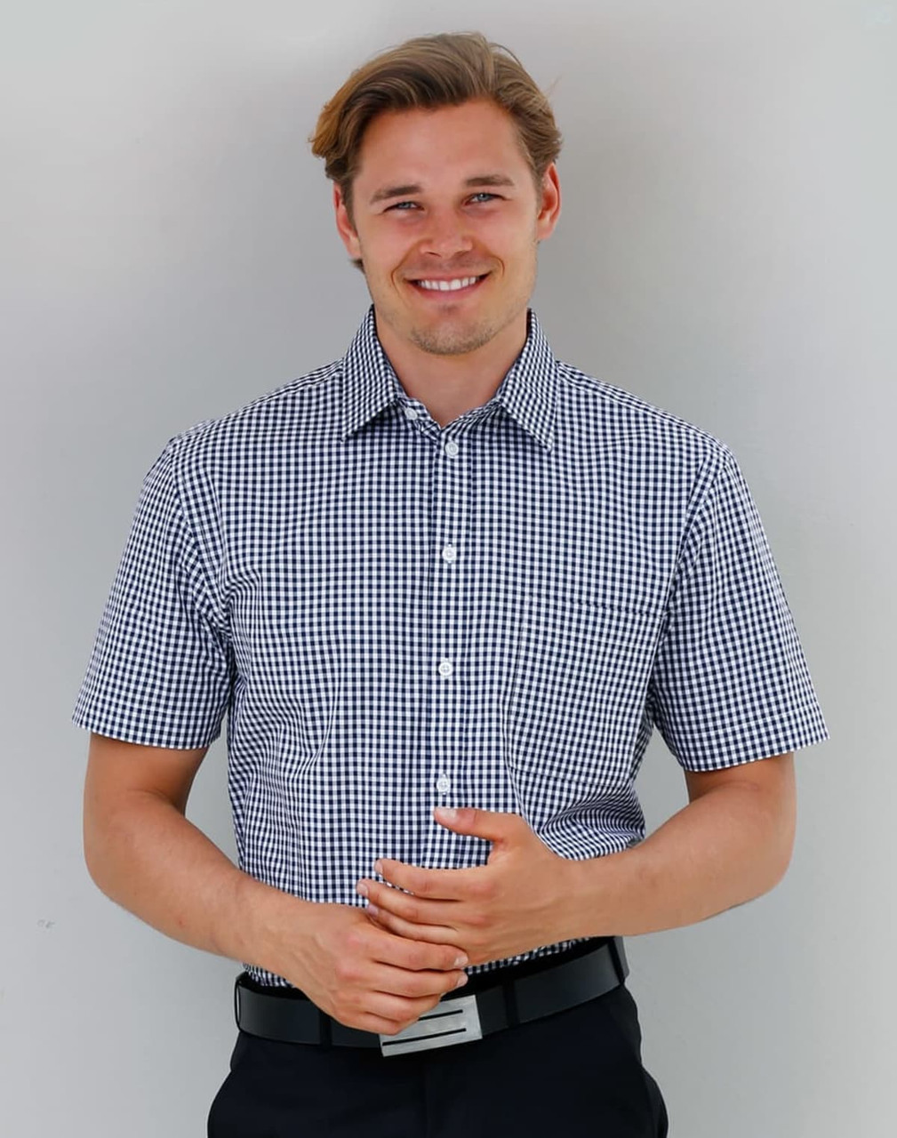 A short-sleeved men's button-up shirt in navy and white gingham check pattern, featuring a logo.