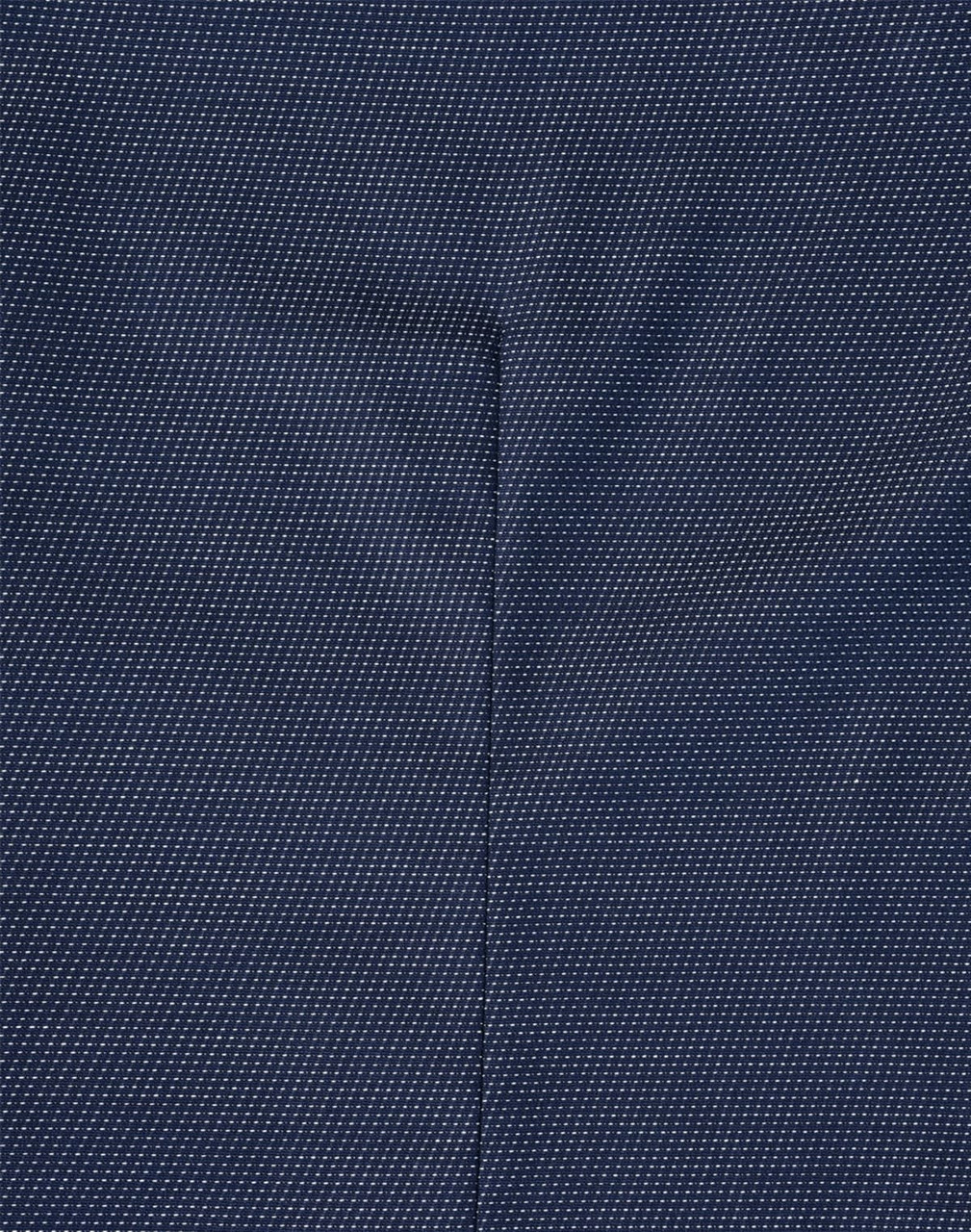 A close-up of a navy blue fabric with a pin dot pattern, showcasing the texture of the shirt.