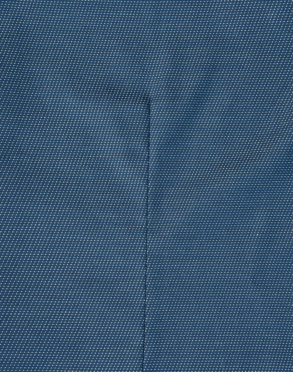 A close-up of a blue pin dot fabric, displaying subtle texture and stitching details typical of a long-sleeved button-up shirt.
